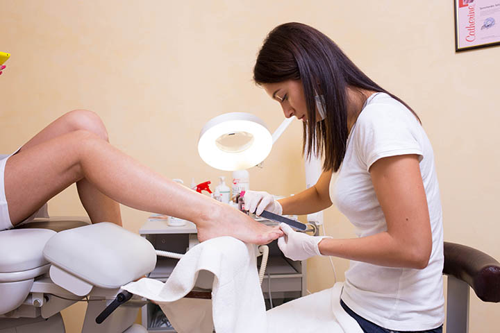 Мастер делает педикюр ногтей пилочкой